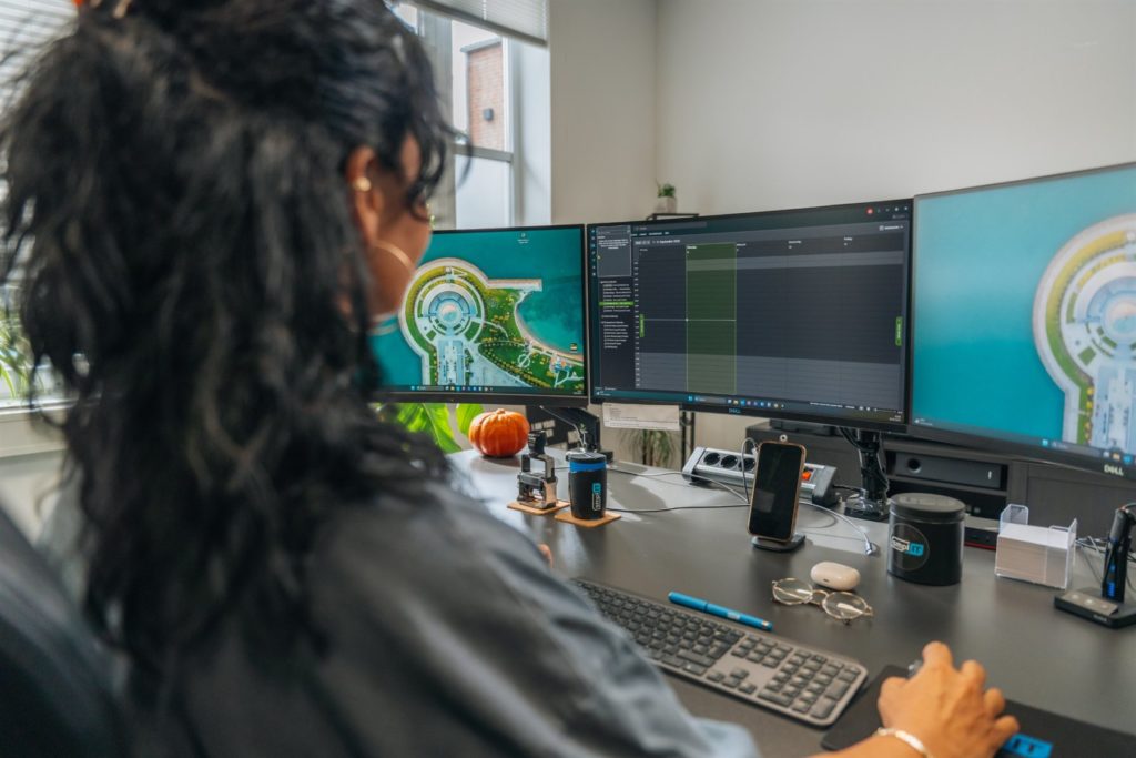 Kollegin am Arbeitsplatz mit drei Monitoren